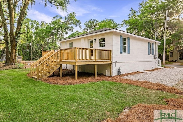 rear view of property with a lawn, a wooden deck, and stairs