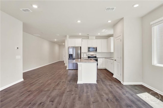 132 Congo Ct, Pooler, GA 31322 - kitchen featuring appliances with stainless steel finishes, baseboards, a kitchen island with sink, white cabinets, and dark wood-type flooring