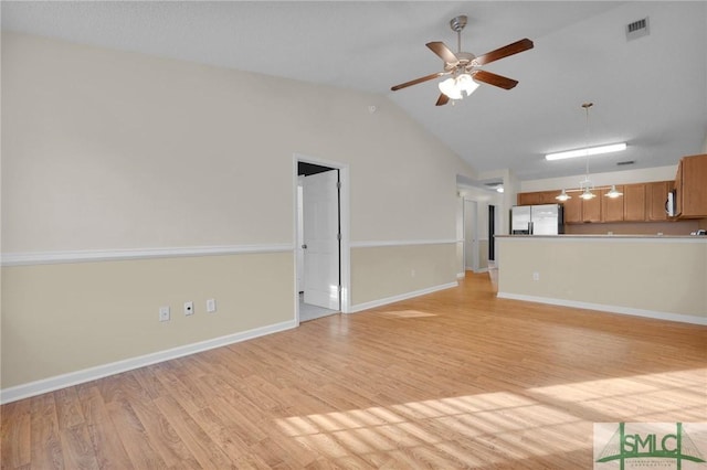 unfurnished living room featuring visible vents, baseboards, light wood-type flooring, a ceiling fan, and vaulted ceiling