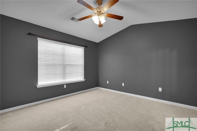 carpeted empty room featuring a ceiling fan, a textured ceiling, visible vents, vaulted ceiling, and baseboards