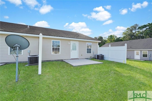 rear view of house featuring a lawn, central AC unit, a patio area, and fence