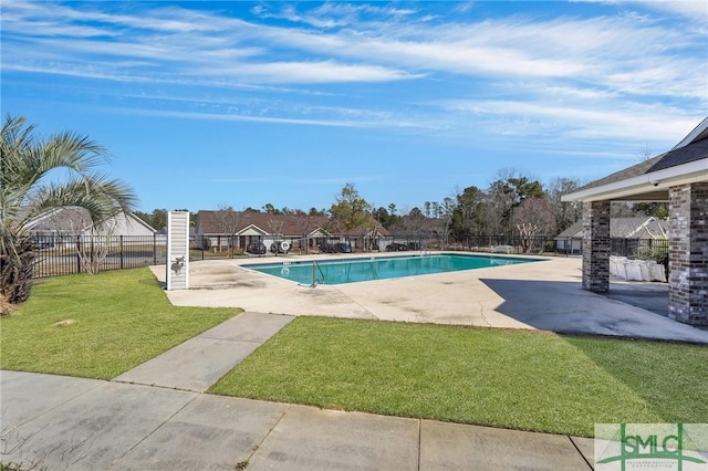 community pool featuring a lawn, a patio area, and fence
