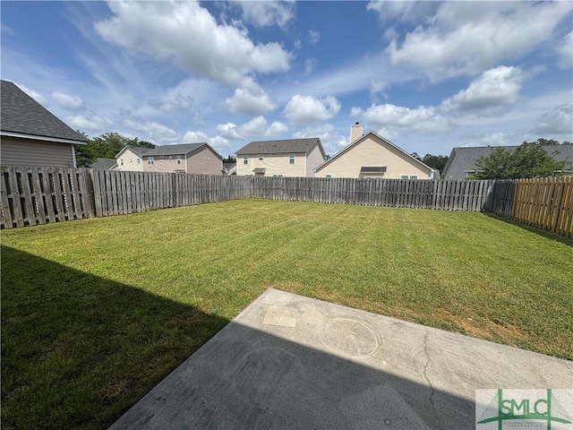 view of yard with a patio, a fenced backyard, and a residential view