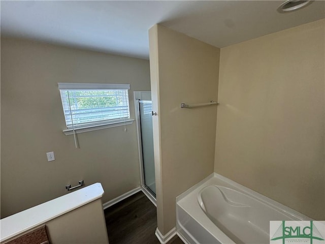 full bathroom featuring baseboards, a bath, wood finished floors, and a shower stall