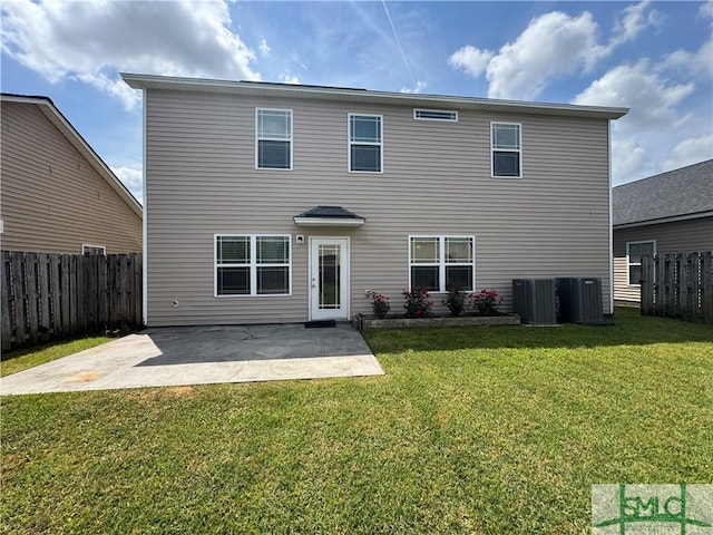 rear view of property featuring a lawn, a fenced backyard, central AC, and a patio area