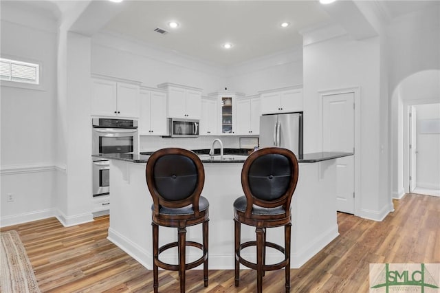 5 Lazy Hammock Ct, Savannah, GA 31419 - kitchen with light wood-type flooring, white cabinetry, appliances with stainless steel finishes, and a breakfast bar area