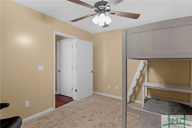 unfurnished bedroom featuring carpet floors, baseboards, and ceiling fan