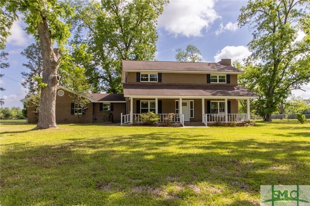 view of front of house with covered porch, a chimney, and a front lawn
