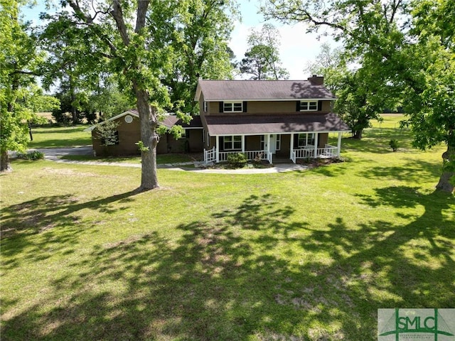 view of front facade with covered porch, a chimney, and a front lawn