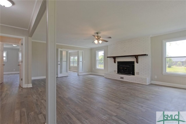 unfurnished living room with crown molding, a ceiling fan, baseboards, and wood finished floors