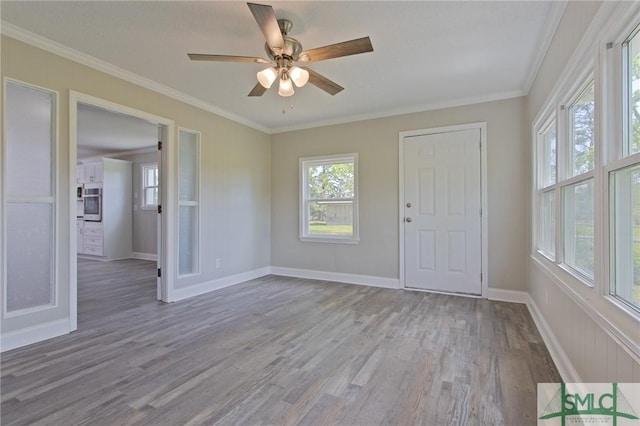 unfurnished room featuring crown molding, baseboards, a ceiling fan, and wood finished floors