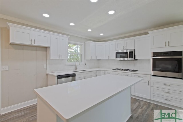 kitchen featuring a sink, appliances with stainless steel finishes, crown molding, and dark wood-style flooring