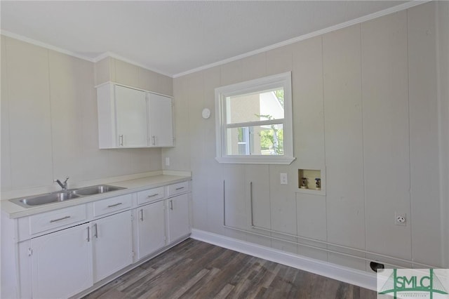 washroom with crown molding, cabinet space, a sink, hookup for a washing machine, and dark wood-type flooring