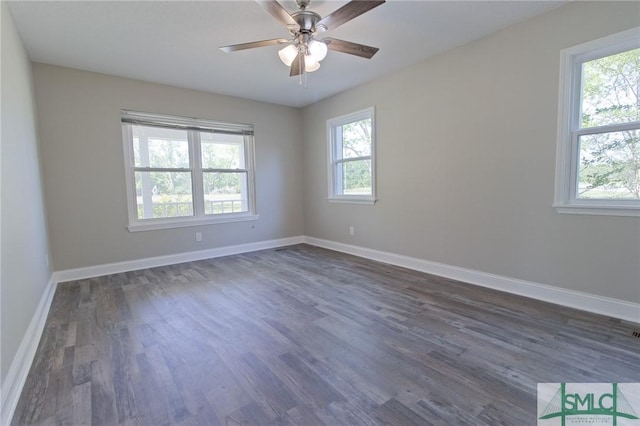 spare room with baseboards, ceiling fan, and dark wood-style floors