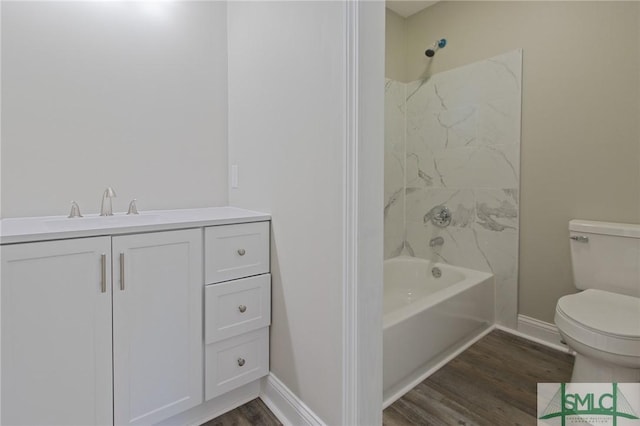 bathroom featuring vanity, wood finished floors, toilet, baseboards, and  shower combination