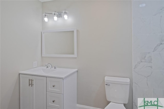bathroom featuring vanity, baseboards, and toilet
