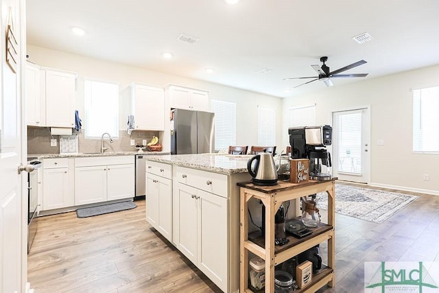 166 Benelli Dr, Pooler, GA 31322 - kitchen with a center island, a ceiling fan, light wood finished floors, and stainless steel appliances