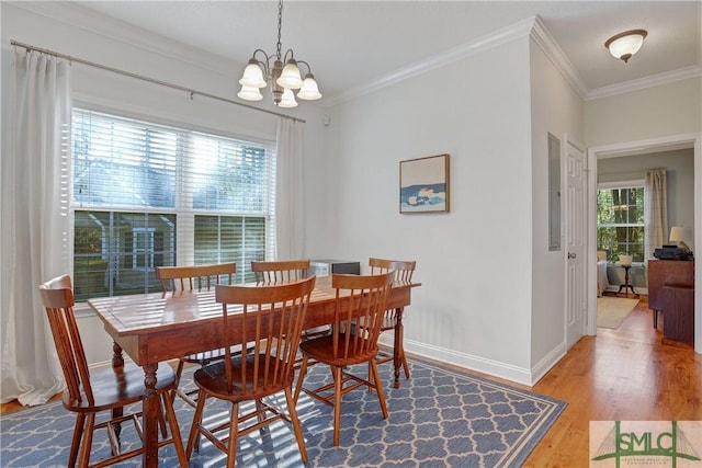dining room with crown molding, baseboards, wood finished floors, and a notable chandelier