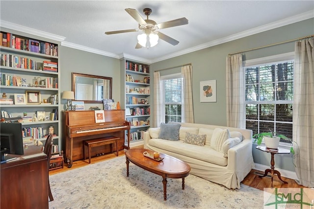 sitting room with crown molding, a ceiling fan, and wood finished floors