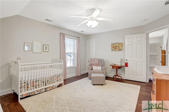 bedroom featuring visible vents, a ceiling fan, dark wood finished floors, and baseboards