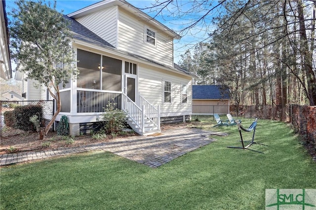 back of property with roof with shingles, a lawn, a sunroom, fence, and a patio