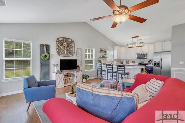 living room with baseboards, plenty of natural light, light wood-type flooring, and ceiling fan
