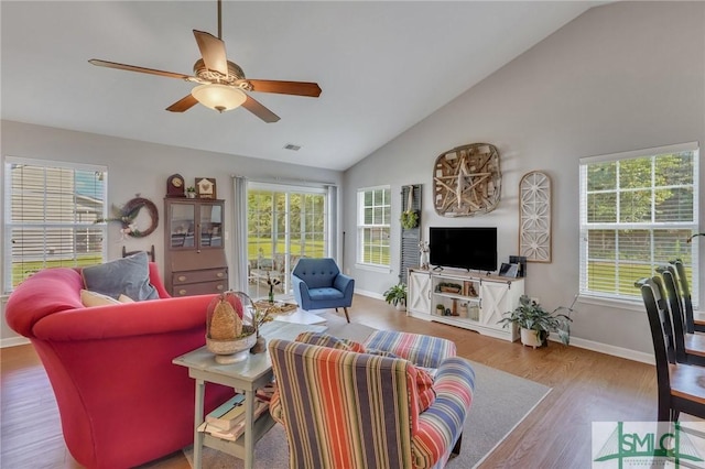 living area with a ceiling fan, baseboards, and a wealth of natural light