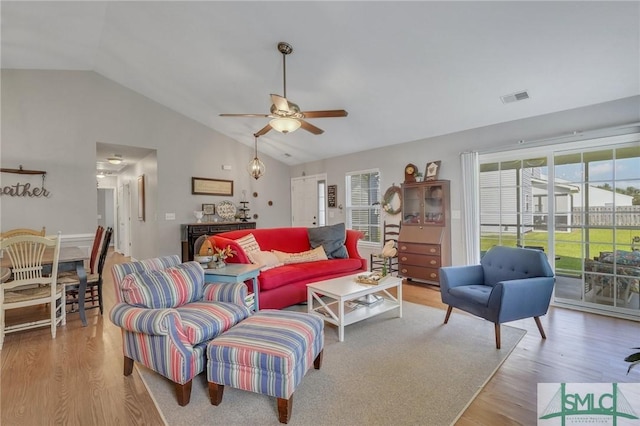 living room featuring visible vents, a ceiling fan, vaulted ceiling, and a healthy amount of sunlight