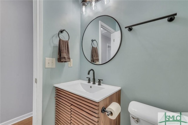 half bath featuring toilet and vanity