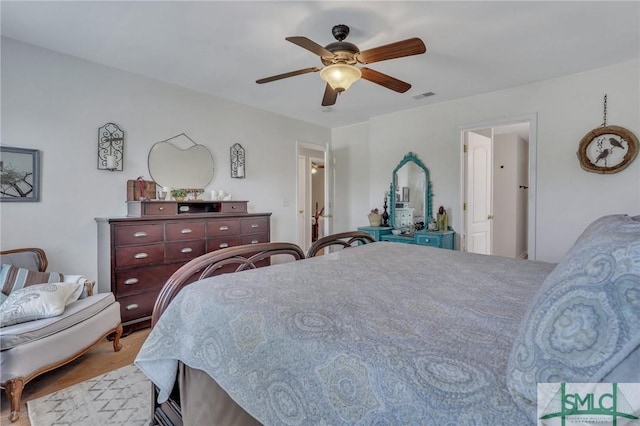 bedroom featuring a ceiling fan, wood finished floors, and visible vents