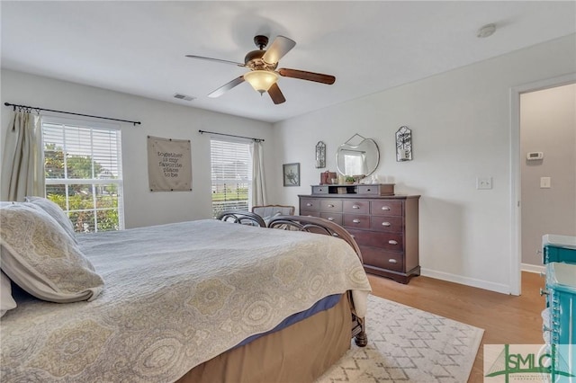 bedroom with visible vents, a ceiling fan, light wood-style flooring, and baseboards
