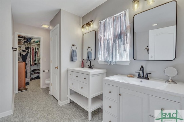 full bath featuring a sink, baseboards, tile patterned floors, and two vanities