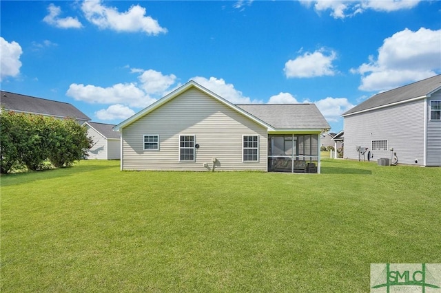 rear view of house featuring a lawn, cooling unit, and a sunroom