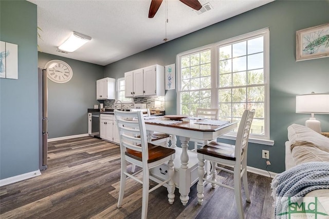 dining room with dark wood-style flooring, a ceiling fan, baseboards, and visible vents