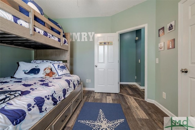 bedroom with dark wood-style flooring and baseboards