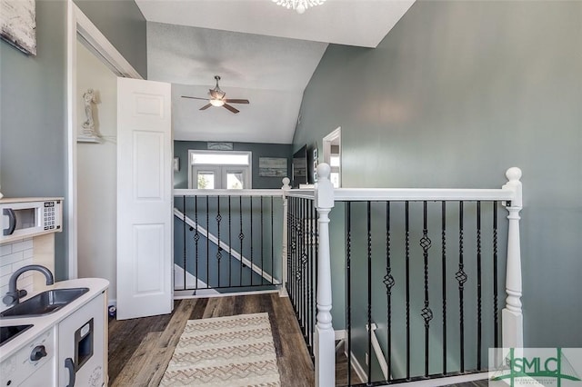 stairs with a ceiling fan, lofted ceiling, and wood finished floors