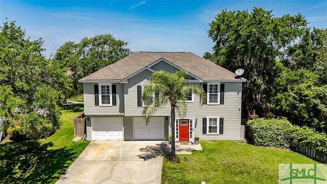 raised ranch featuring driveway, a shingled roof, a front lawn, and a garage