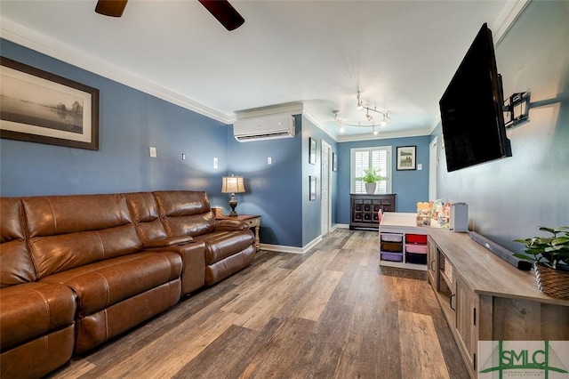 living room with crown molding, an AC wall unit, a ceiling fan, baseboards, and wood finished floors