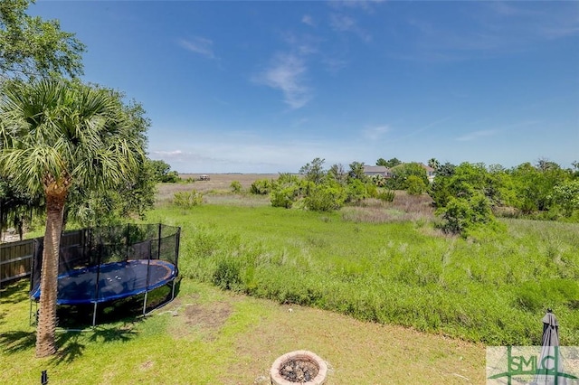 view of yard with fence and a trampoline