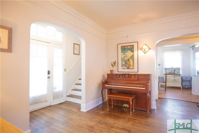 foyer with plenty of natural light, arched walkways, and stairs