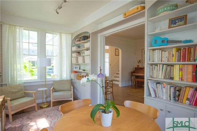sitting room featuring stairway, arched walkways, crown molding, and a wealth of natural light