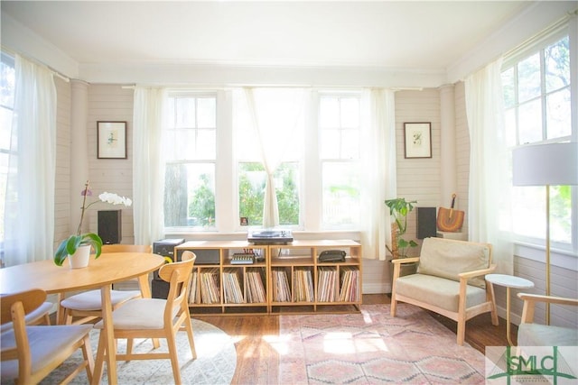 living area with ornamental molding, a healthy amount of sunlight, and wood finished floors