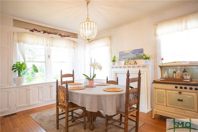 dining room with light wood-style flooring, a chandelier, and a wealth of natural light