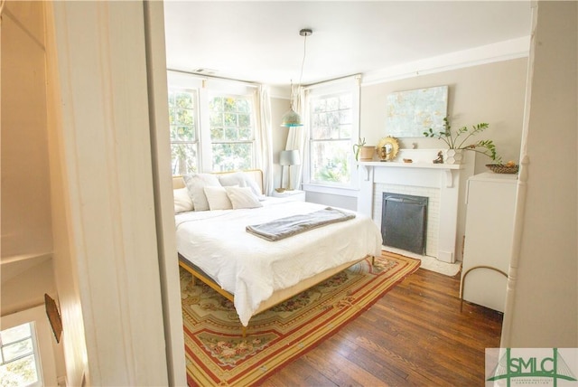 bedroom featuring a fireplace and dark wood-type flooring