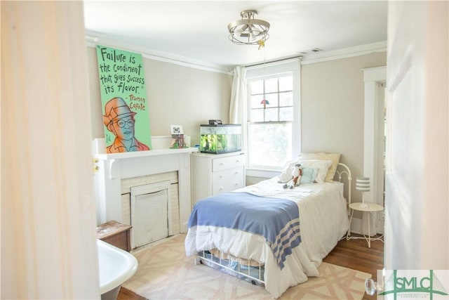 bedroom with visible vents, ornamental molding, and wood finished floors