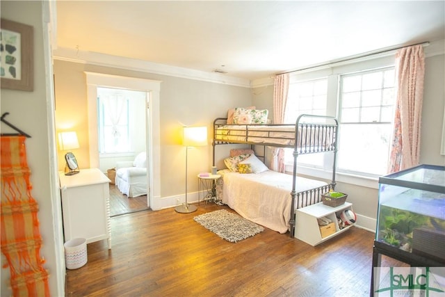 bedroom featuring crown molding, multiple windows, and wood finished floors