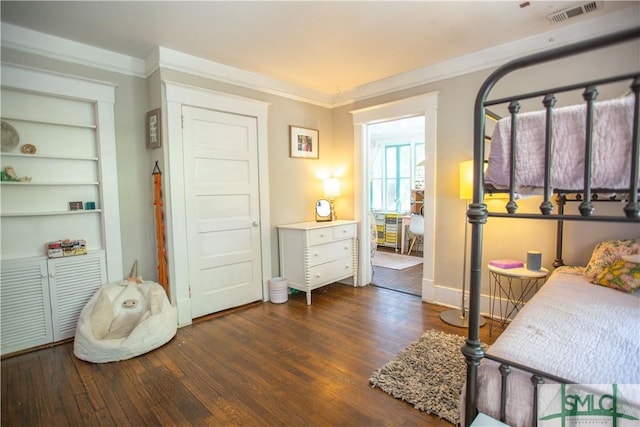 bedroom featuring baseboards, visible vents, ornamental molding, and wood finished floors