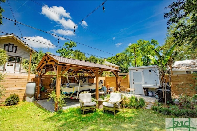 view of patio with fence, heating fuel, and a gazebo