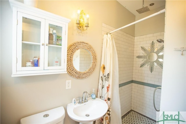 bathroom with a sink, toilet, and a shower stall