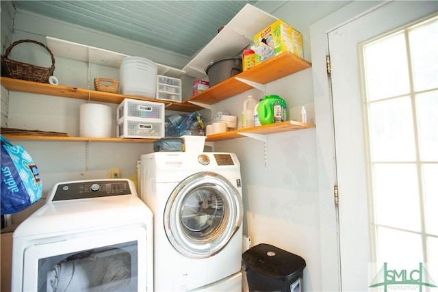 clothes washing area with laundry area, washing machine and dryer, and a wealth of natural light